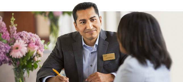 A smiling associate helping a lady